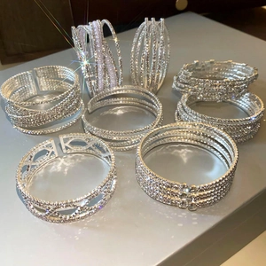 Macro-opname van sprankelende strass-armbanden en parelringen met crossover-ontwerp