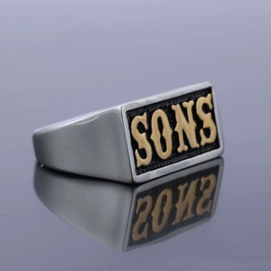 Détail macro d'une bague punk pour homme avec texte SONS doré sur anneau poli argent
