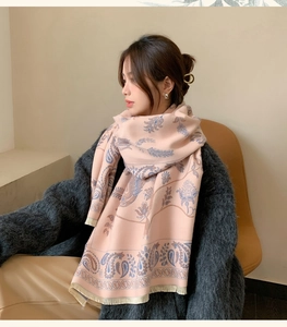 Ein Model trägt einen rosa Schal mit Retro-Paisley-Muster für wohlige Winterwärme