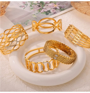 Close-up of five layered gold titanium steel bangles with hollow patterns and small diamonds