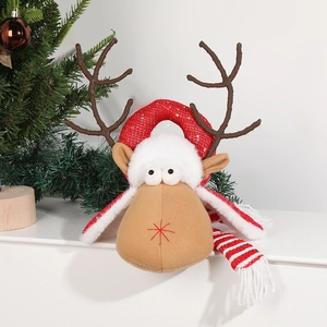 Plush Christmas reindeer decoration with sequin antler ring and striped scarf on white floor