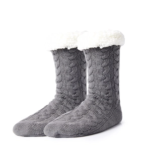 Detail view of grey cable-knit slipper socks with thick white fleece lining and soft cuffs