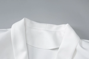 Detailed macro view of white dress neckline showing smooth fabric and neat stitching craftsmanship