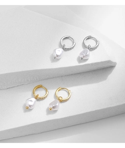 Detail of baroque pearl hoop earrings with crystal pave settings in gold and silver