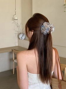 Dettaglio molletta per capelli a fiore grande in organza con sfumatura blu e rosa
