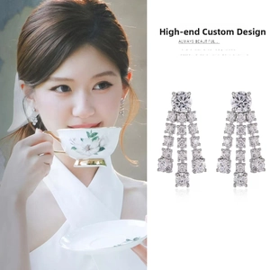 Detail of silver tassel earrings with sparkling cubic zirconia crystals on an Asian model