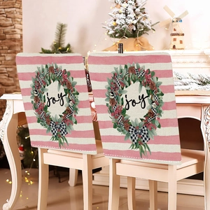 Close-up of pink Christmas chair covers featuring Joy wreaths and festive bows