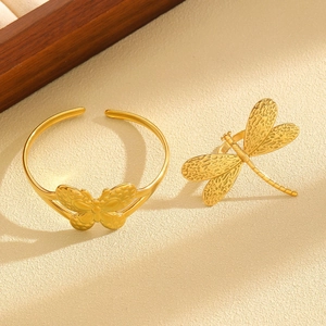 Detailed view of gold butterfly open cuff bracelet and dragonfly ring set for women