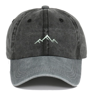 Close-up of mountain embroidery and washed cotton texture on a grey baseball cap