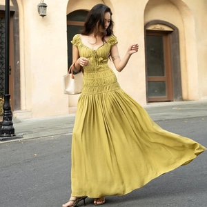 Détail de la texture du tissu et de la taille élastique plissée de cette robe maxi jaune