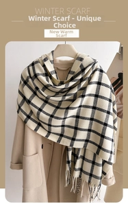 Detail of warm checkered winter scarf with fringes on a beige woolen coat