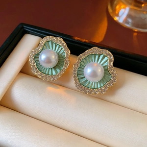 Macro de boucles d'oreilles coquillage émail vert menthe avec perles et cristaux sur beige