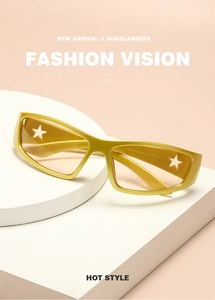 Detail of gold star cutout sunglasses with yellow lenses on a peach background