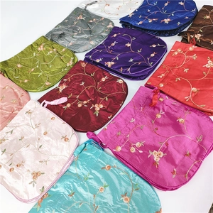 Macro detail of assorted colorful floral embroidery on drawstring silk satin bags