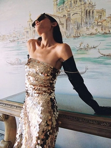 Detail of shimmering gold oversized sequins on a slim-fit backless party evening dress