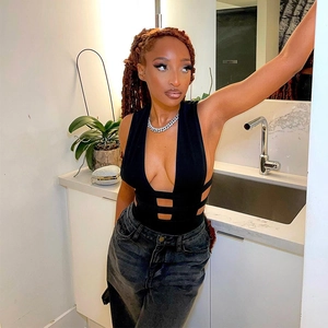 Détail d'une combinaison noire ajourée avec décolleté en V et coupe slim à la taille