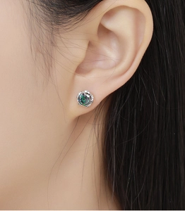 Macro shot of 925 silver stud earring with a round colorful aurora gemstone inlay