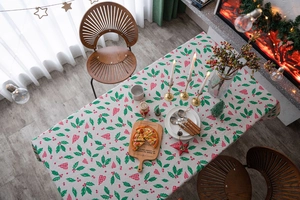 Detail of Christmas tablecloth featuring holly leaves, berries and red plaid heart patterns