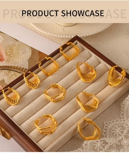 Detail of assorted golden geometric earrings in a luxury jewelry display box