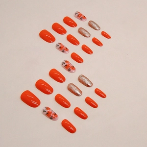Faux ongles ovales orange à paillettes argentées avec motifs citrouille