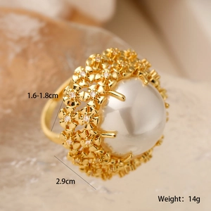 Macro shot of 18K gold flower ring featuring central pearl and sparkling zircon details