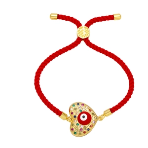 Adjustable red rope bracelet with golden heart charm featuring a red evil eye and gems