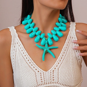 Close-up of turquoise acrylic beaded necklace with a detailed starfish pendant on a model