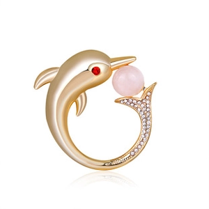 Macro detail of a dolphin ring with pink pearl, red accents, and pavé set crystals