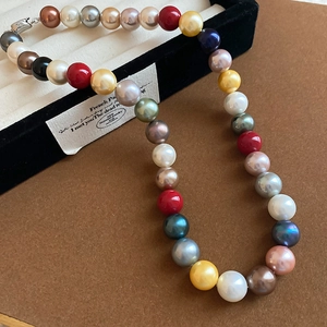 Close-up of a colorful pearl necklace with a metal clasp inside a black jewelry gift box