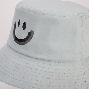 Close-up of light grey cotton bucket hat with smile print and twill fabric detail