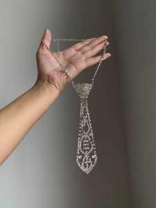 Detailed close-up of a silver-tone rhinestone tie necklace with long tassel design