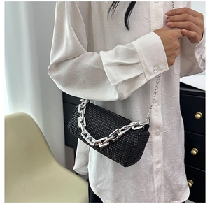 Borsa a cilindro nera con strass e catena d'argento spessa indossata da una modella
