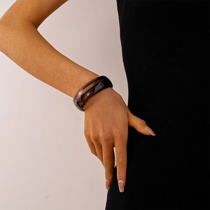 Detailansicht eines breiten Bernstein-Resin-Armreifs mit Marmorierung am Handgelenk