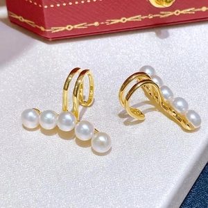 Detail of five freshwater pearls on a gold-plated clip-on earring with red jewelry gift box