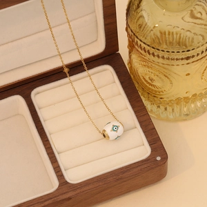 Golden stainless steel heart necklace with blue evil eye enamel charm in a wooden gift box