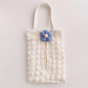 Detail of white popcorn fabric car tissue box with a cute blue plush flower decoration