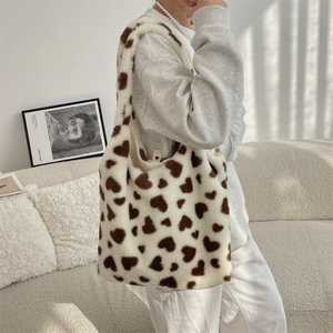 Detailed plush texture of white tote bag with brown heart patterns and soft fur fabric