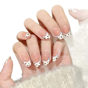 Faux ongles French avec base rose et motifs vache bleus sur pointes blanches
