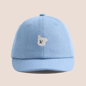 Détail de la broderie d'ours sur le tissu en jean bleu clair d'une casquette bébé