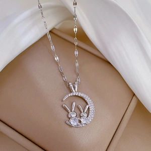 Close-up of titanium steel crescent moon and rabbit pendant with sparkling crystals
