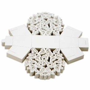 Flat stacked white laser-cut butterfly candy boxes with intricate hollow patterns