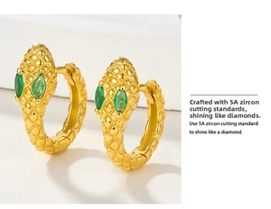 Macro shot of s925 silver snake earrings with green zircon eyes and textured gold plating
