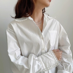 Close-up of white cotton shirt with intricate lace hollow-out details on the collar and cuffs