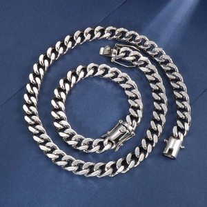 Silbernes Set aus Cuban-Gliederkette und Armband mit Schmuckverschluss auf blauem Grund