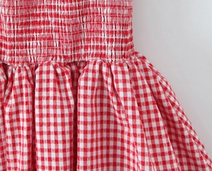 Detailed macro shot of the red and white gingham fabric with elastic smocked waist details
