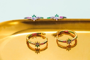 Macro shot of 18K gold and silver plated earrings with colorful zircon and star charm