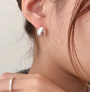 Polished S925 silver teardrop earrings and wavy ring shown on a model for a minimalist look