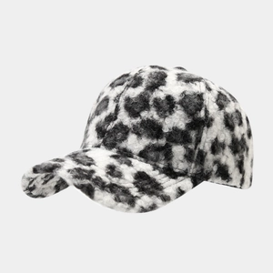 Close-up of fluffy black and white leopard print baseball cap with warm plush texture