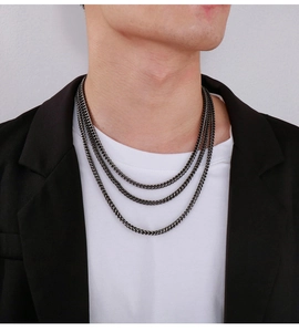 Close-up of triple-layered gunmetal steel dragon bone chains on black blazer