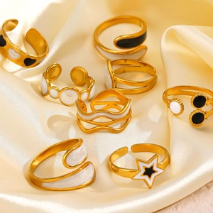 Detail view of gold-plated star and heart enamel rings on premium silk background
